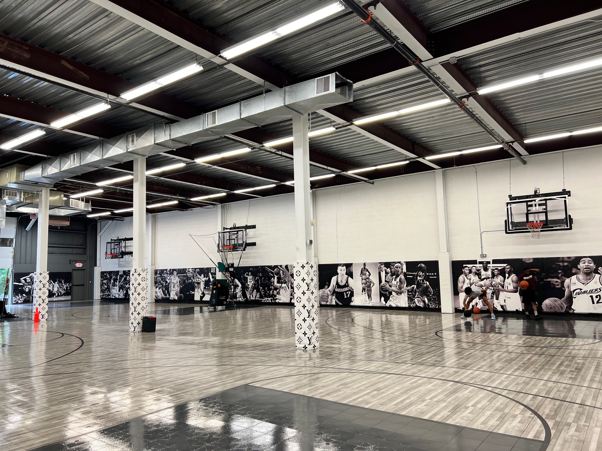 Wide-angle view of the Kulture Basketball indoor facility showing the expansive court with multiple hoops and NBA wall murals